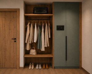A walk-in closet with hanging clothes, a suitcase on top, and a door with a keypad lock. - The Hideaway: Arrive, unwind, and simply feel at home. (Kaltenbach)