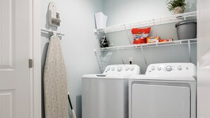 A laundry room with two front-loading washing machines, a drying rack, and a mopping bucket. - Ocean Views, Elevator, Fire Pit (Surf City)