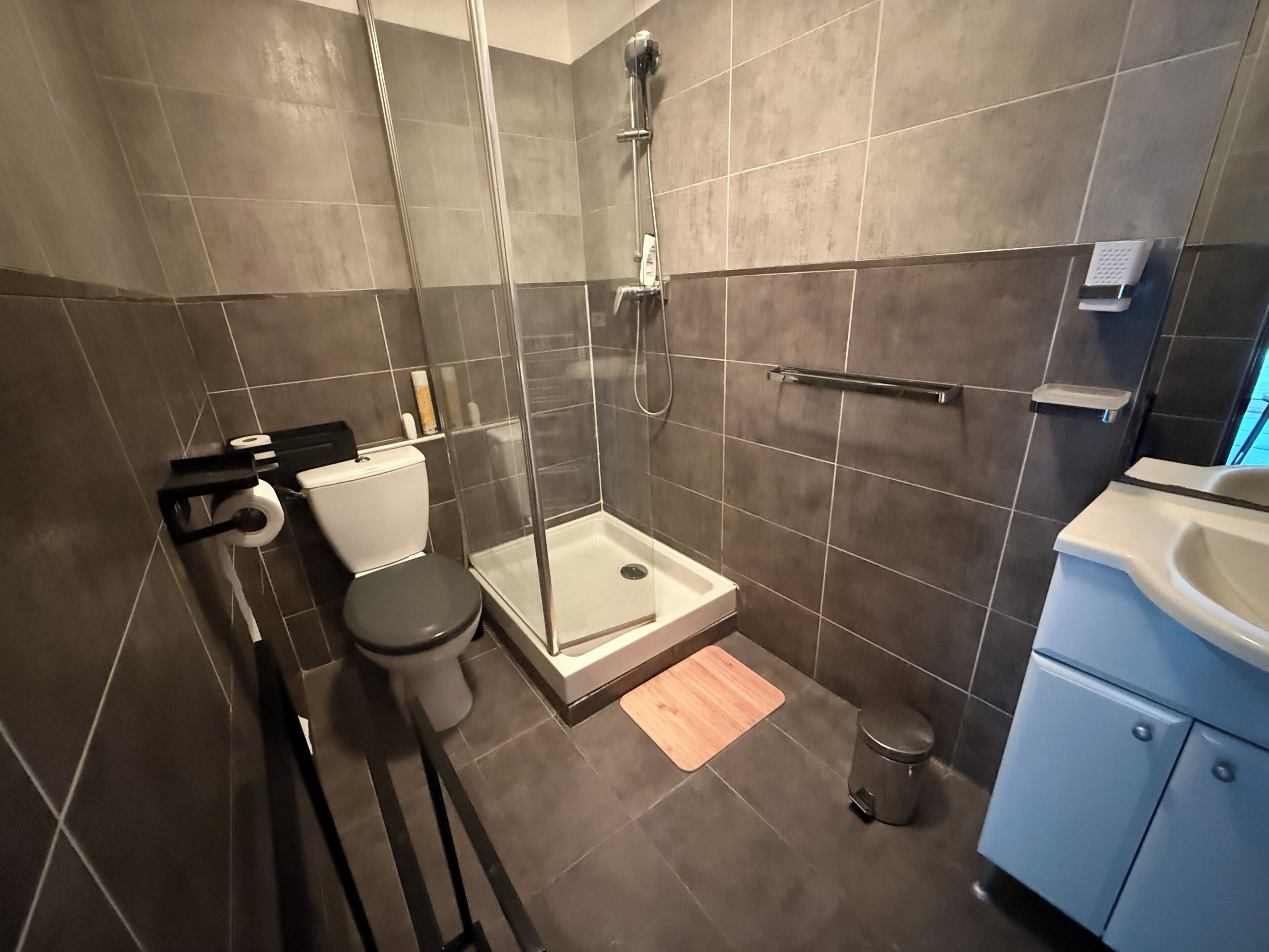 A modern bathroom with a shower, toilet, and sink.