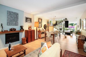 A spacious living area with a fireplace, dining table, and comfortable seating. - Stunning Home in the Heart of Surry Hills (Surry Hills)