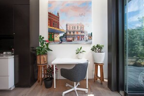 A modern room with a white desk, a gray office chair, and three potted plants. - Stunning Home in the Heart of Surry Hills (Surry Hills)