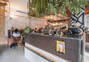 A coffee shop with a counter, seating area, and hanging plants. - Stunning Home in the Heart of Surry Hills (Surry Hills)