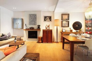 A modern living room with a fireplace, a dining area, and a sofa. - Stunning Home in the Heart of Surry Hills (Surry Hills)