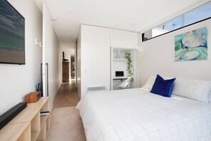 A modern bedroom with a bed, a desk, and a bookshelf. - Stunning Home in the Heart of Surry Hills (Surry Hills)