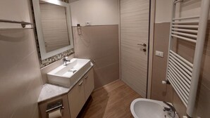 A modern bathroom with a sink, mirror, and shower area. - Cozy Apartment in La Spezia—La Spezia's Little Gem (La Spezia)