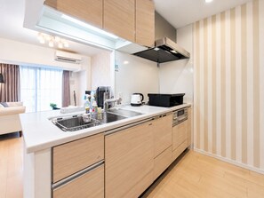 A modern kitchen with a built-in stove, a coffee maker, and a kettle on the counter. - SERENE | Kuromon · 1006 | 60 m² · 2BR | Sleeps 6 | Family Suite | 2 min to Kuromon (大阪市)