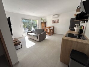 Ein zeitgemäßer Wohnbereich mit Sofa, Esstisch und Küchenzeile.