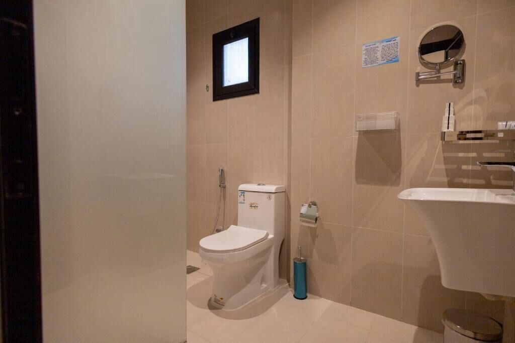 Une salle de bain moderne équipée de toilettes, d’un lavabo et d’un miroir.