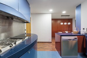 Eine moderne Küche mit Edelstahlherd, Geschirrspüler und einem Essbereich mit Holztisch.