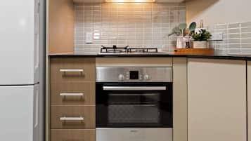 A kitchen with a Bosch oven, a gas stove, and a refrigerator.