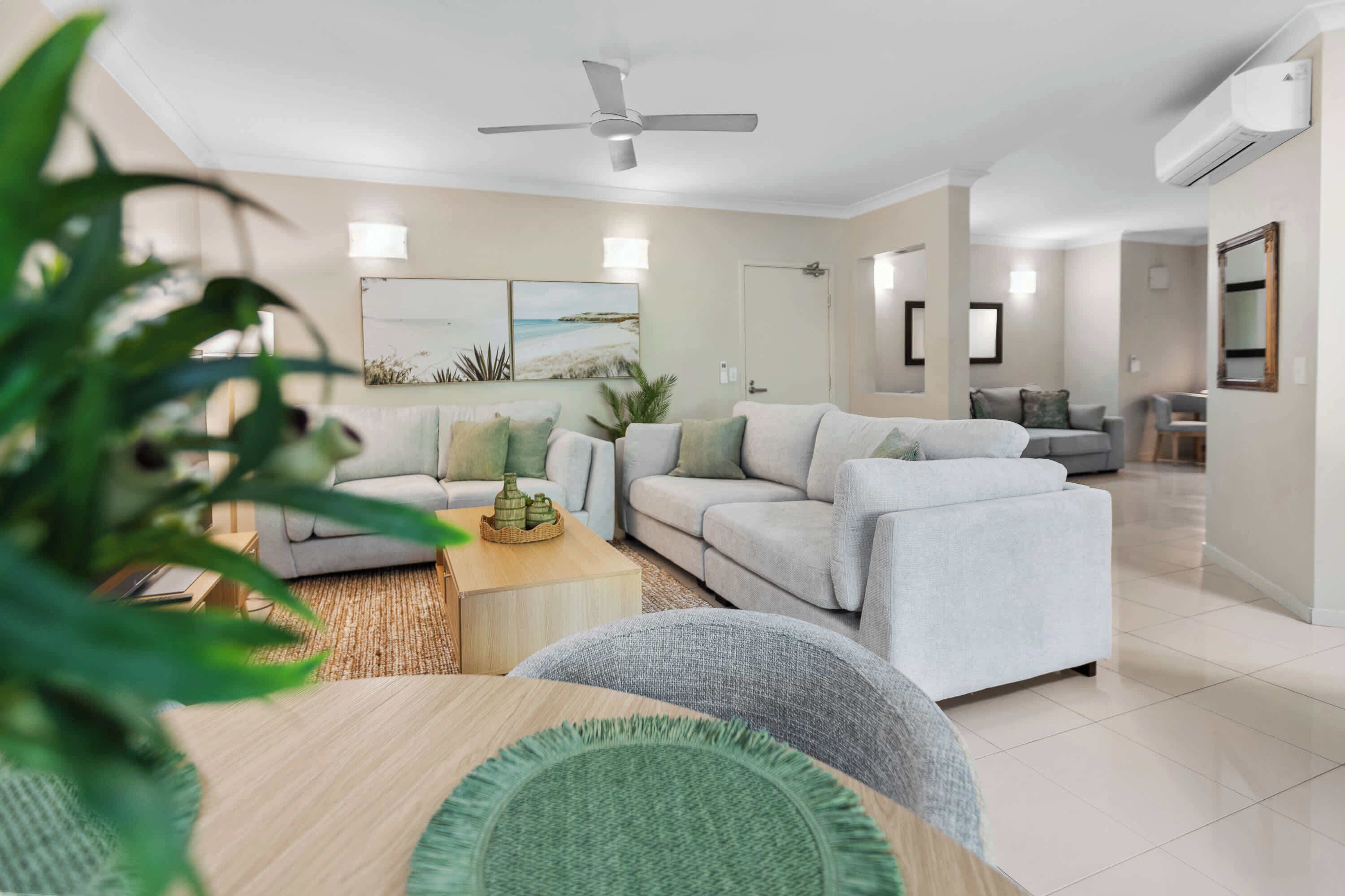 A modern living room with a sectional sofa, a coffee table, and a ceiling fan.