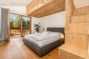 A bedroom with a bed, a potted plant, and a view of the outdoors. - Chalet with a terrace hot tub and sauna (Reit im Winkl)