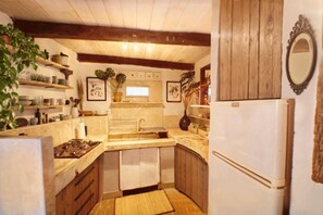 Une cuisine avec des meubles de rangement en bois, un évier et une cuisinière.