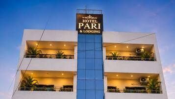 Monikerroksinen hotelli, jonka julkisivussa on suuri, huomiota herättävä kyltti, jossa lukee: ”HOTEL PARI & LODGING”.