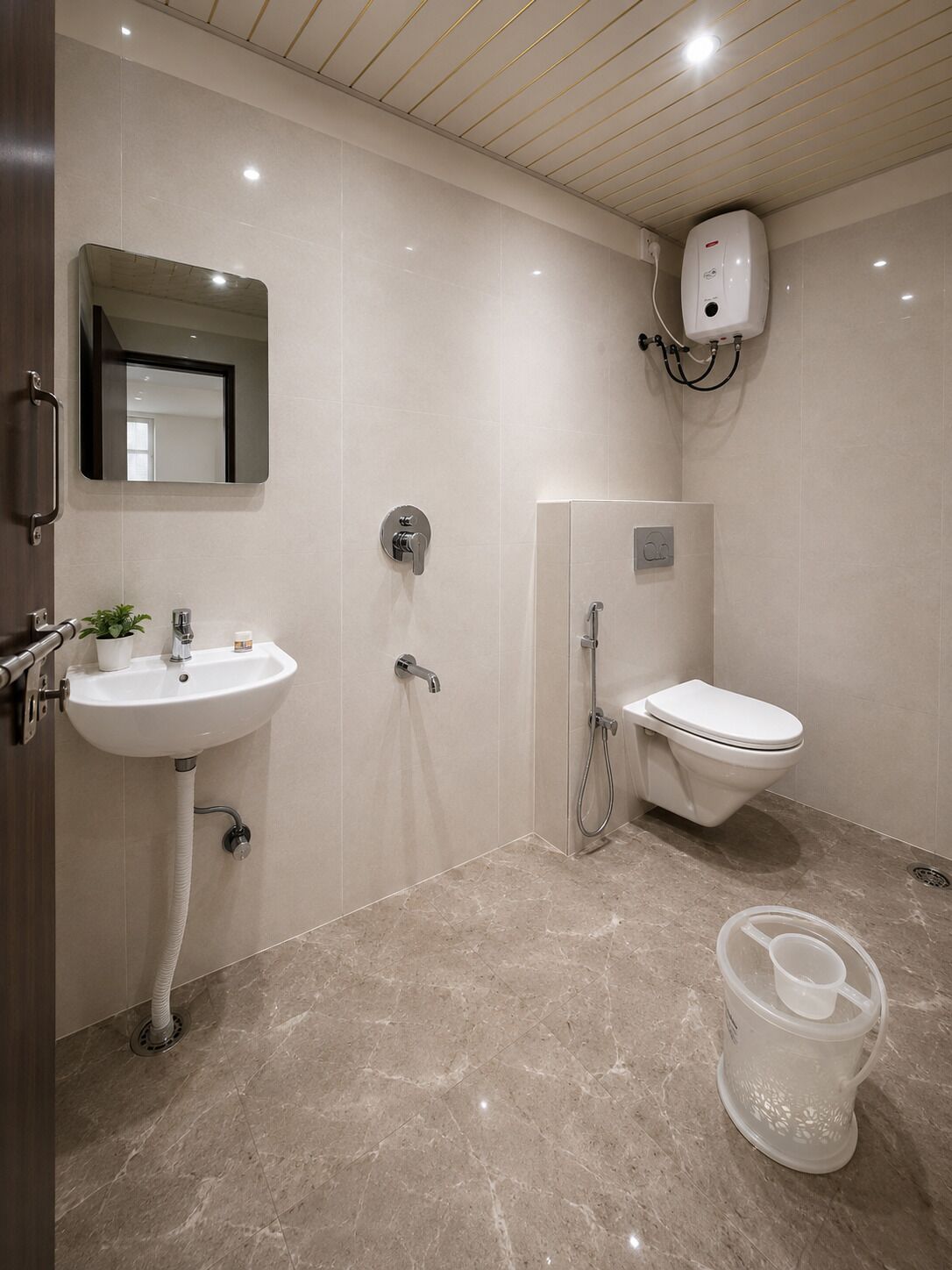 Un baño moderno con lavamanos, espejo, inodoro y ducha.