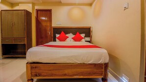 Un dormitorio con estructura de cama de madera, un armario y una lámpara en el techo.