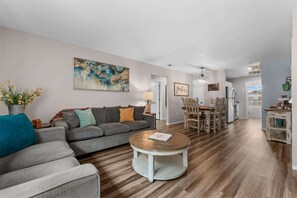 Ein Wohnzimmer mit Sofa, Couchtisch und einem Bild an der Wand.