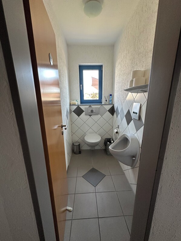 Ein kleines Badezimmer mit Toilette, Bidet und einem kleinen Fenster.