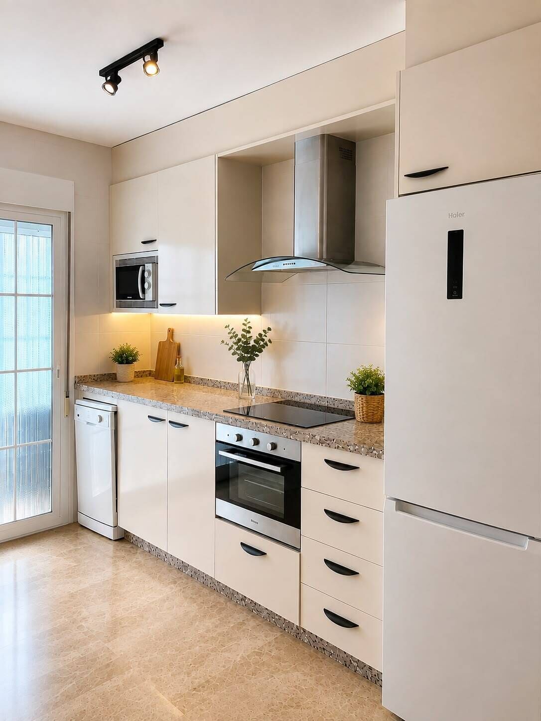 Eine moderne Küche mit weißen Schränken, einem eingebauten Backofen, einer Mikrowelle und einer Edelstahl-Dunstabzugshaube.