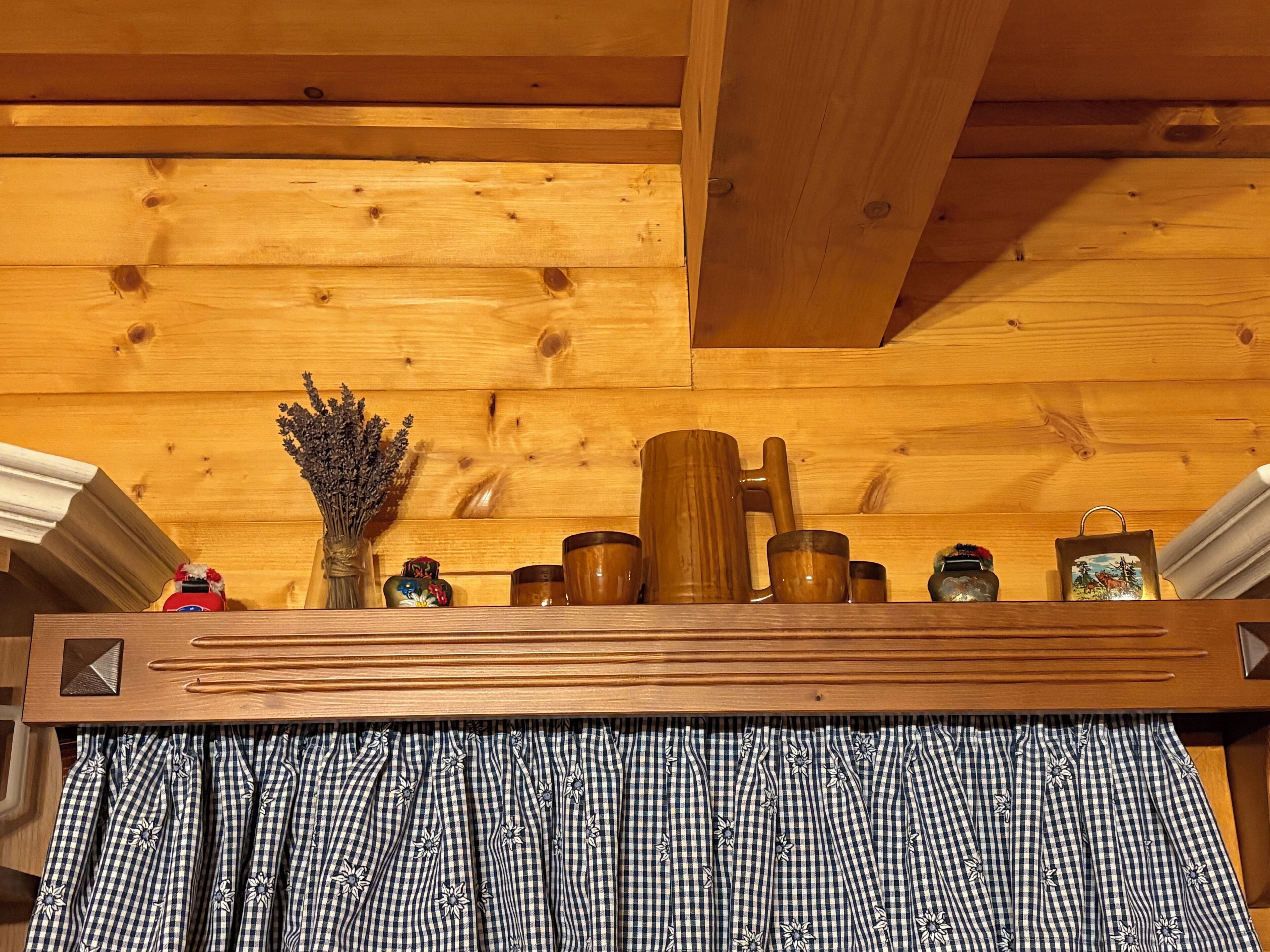 Une étagère en bois sur laquelle sont disposés divers objets, notamment un vase, des tasses et un objet décoratif.
