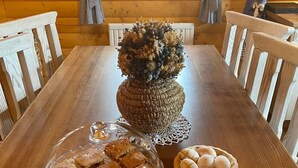 Ein Holztisch mit einem Glastortenständchen, einer gewebten Tischdeko und einer Schüssel mit Eiern.