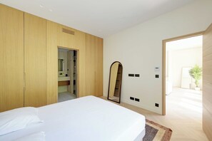 A modern bedroom with a large bed, wooden wardrobe, a full-length mirror, and a door leading to a bathroom. - Modern a/c - 2bdr/4p Flat - Montorgueil (Paris)