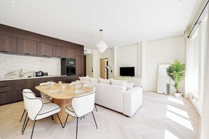 A modern living room with a dining area, a sofa, a TV, and a potted plant. - Modern a/c - 2bdr/4p Flat - Montorgueil (Paris)