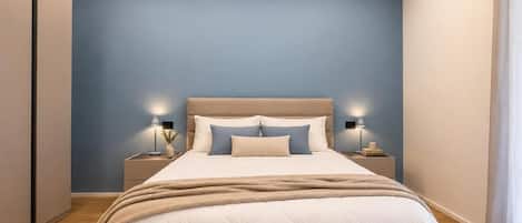A bedroom with a bed, bedside tables, and a nightstand.