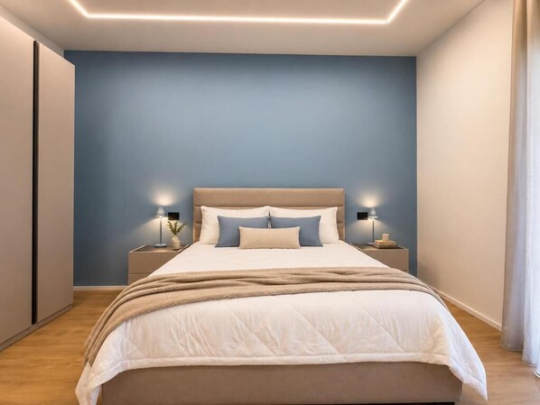 A bedroom with a bed, bedside tables, and a nightstand.