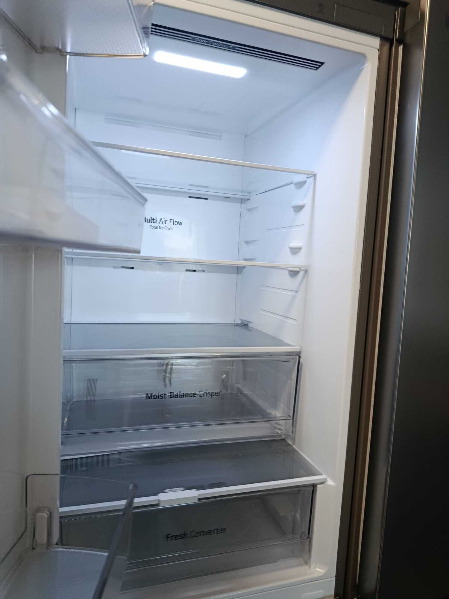Een lege koelkast met etiketten die functies aangeven zoals 'Multi Air Flow', 'Total No Frost', 'Moist Balance Crisper' en 'Fresh Converter'.