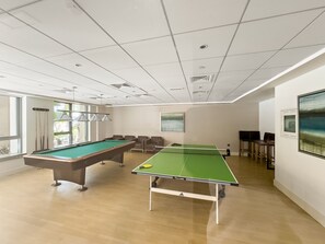 A room with a pool table, ping pong table, and seating area. - Downtown Dubai Escape | 1BR at 29 Boulevard (Dubai)