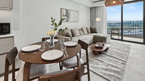 Ett modernt vardagsrum med matplats, soffa och utsikt över staden.