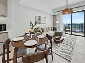 Ein zeitgemäßer Wohnraum mit Essbereich, einer Couch und Blick auf die Stadt.