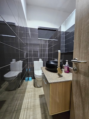 A modern bathroom with a toilet, bidet, and a sink with a soap dispenser. - Eastlands - 1 bedroom apartment, Lekki Phase 1. (Lekki)