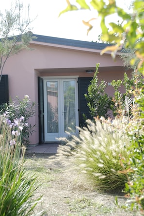 A house with a front door, a small garden, and a clear sky.