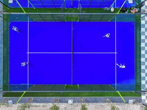 A tennis court with a net and four players.