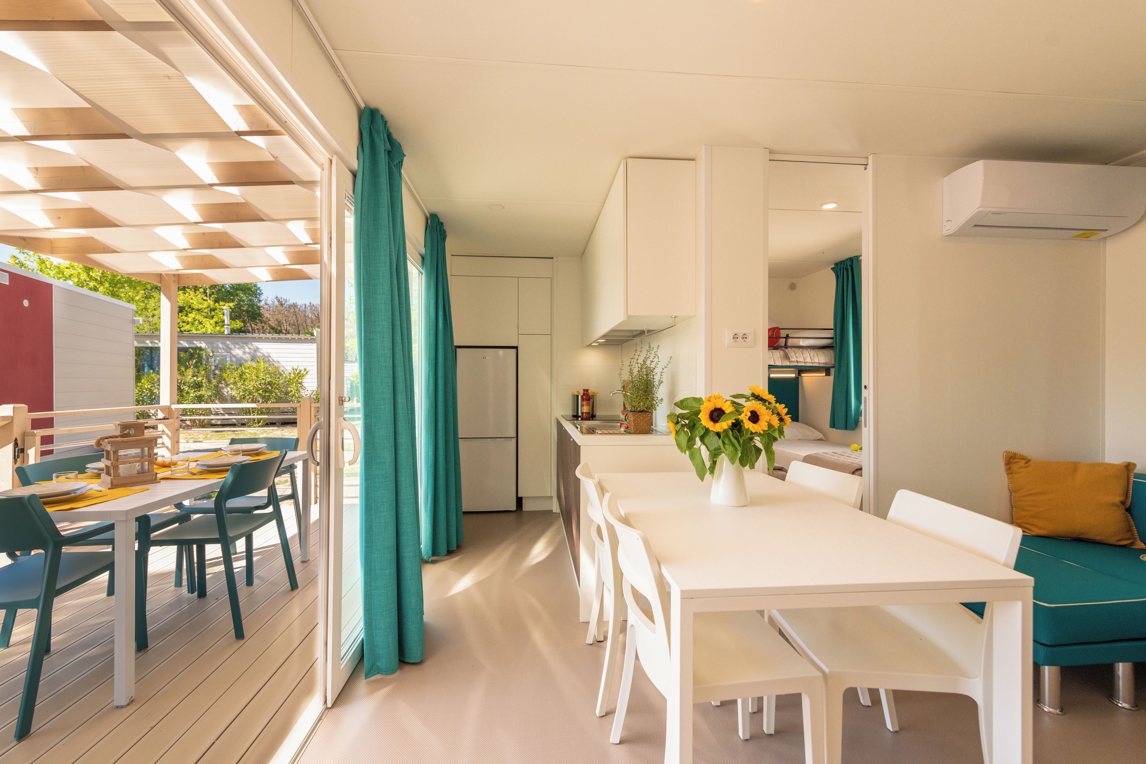 A modern kitchen with a dining area, a refrigerator, and a sink.