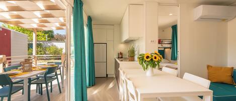 A modern kitchen with a dining area, a refrigerator, and a sink.