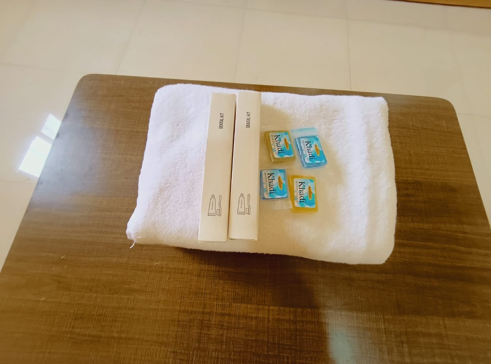 Una mesa de madera con una toalla blanca y un kit de higiene dental.