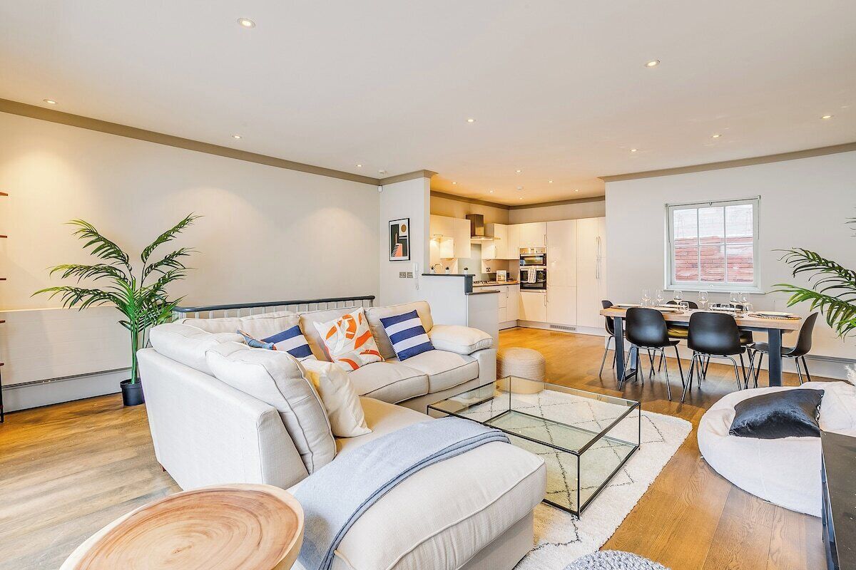 A modern living room with a sofa, coffee table, and dining area.
