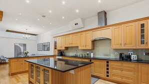 Una cocina moderna con gabinetes de madera, una isla central y electrodomésticos integrados.