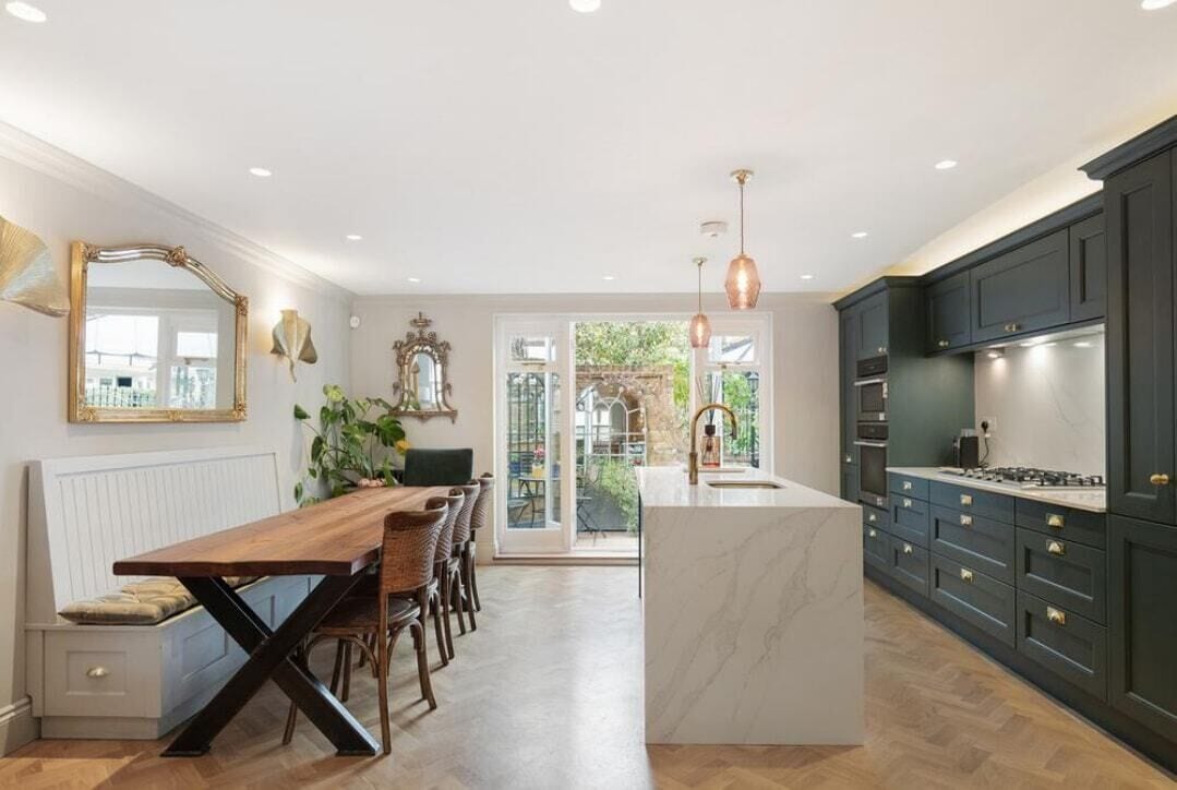 A modern kitchen with a central island, dark cabinetry, and pendant lighting.