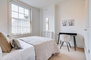 A bedroom with a bed, a desk, and two framed pictures on the wall. - Belgravia - Charming   Spacious 4 Bed Home for 9 (Greater London)