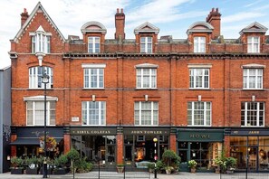 A multi-story brick building with storefronts including 'Sibly Colefax' and 'John Fowler'. - Belgravia - Charming   Spacious 4 Bed Home for 9 (Greater London)