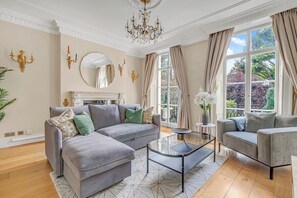 Ein Wohnzimmer mit einer Eckcouch, einem runden Couchtisch und einem Kamin.