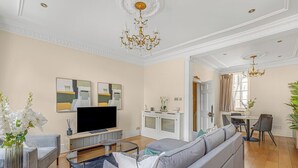 Una sala de estar moderna con sofá, televisor y elementos decorativos.