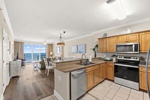 A modern kitchen with a central island, stainless steel appliances, and wooden cabinets. - Ocean Villa 901 ~ beachfront 2 bed 2 bath condo in Panama City Beach (Panama City Beach)