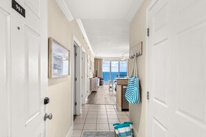 A hotel hallway with a view of the ocean, a beach sign, and a striped towel on the floor. - Ocean Villa 901 ~ beachfront 2 bed 2 bath condo in Panama City Beach (Panama City Beach)