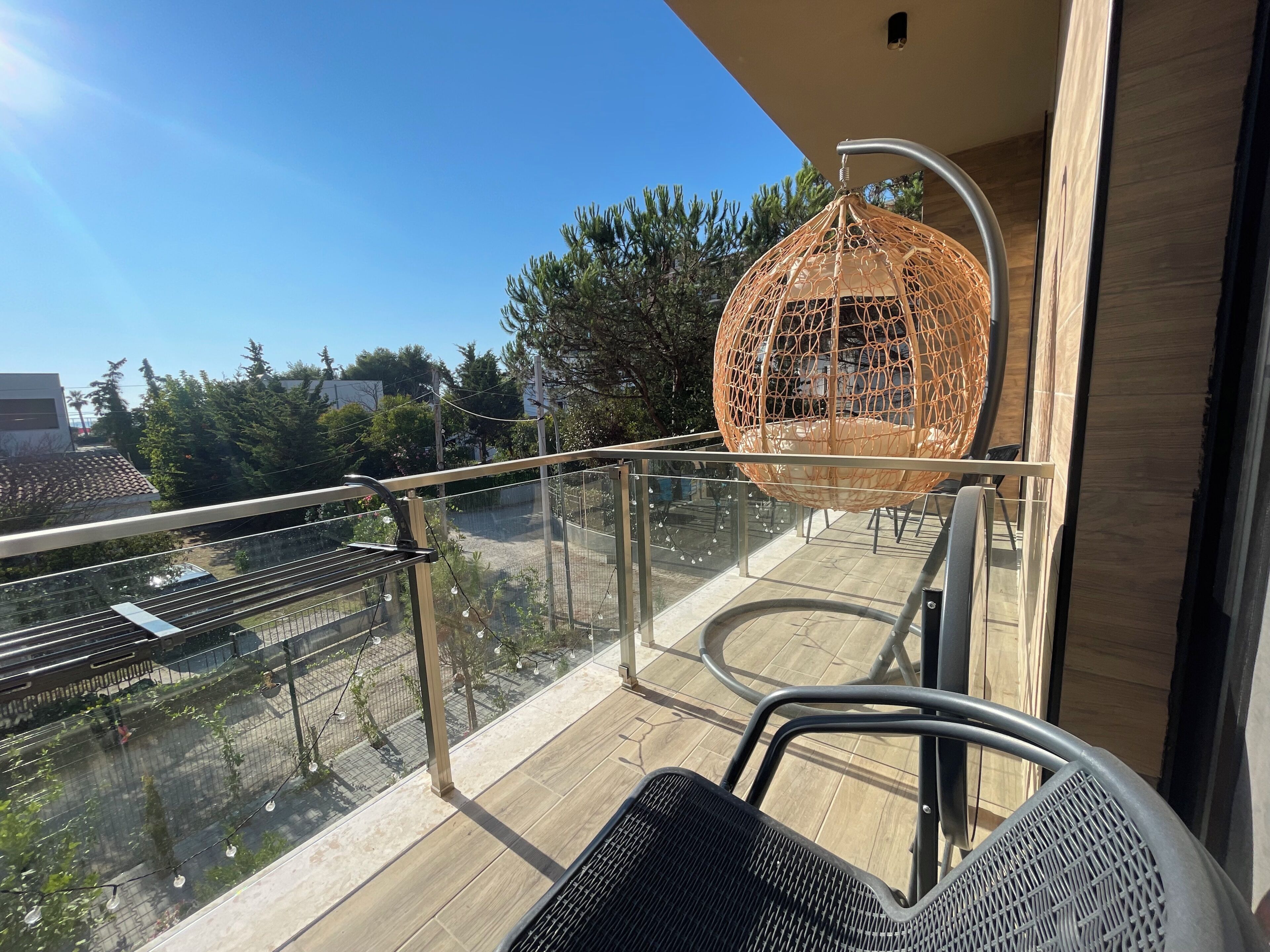 Un balcón con una hamaca colgante, una mesa y una silla.