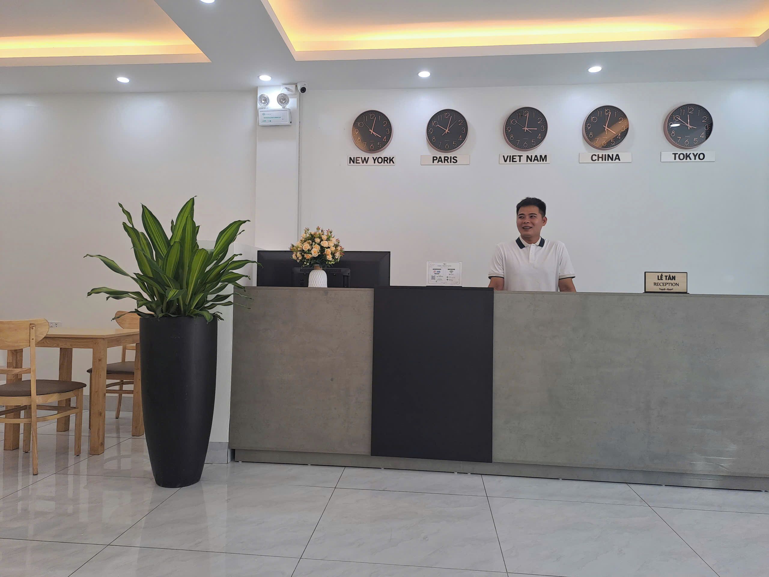 A reception desk with clocks indicating time in New York, Paris, Vietnam, China, and Tokyo.